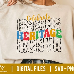 May include: A white sweatshirt with the text "Celebrate Hispanic Heritage Month" in colorful, wavy letters.