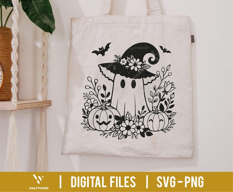 Op de afbeelding: Een cr&egrave;mekleurige draagtas met een zwart-witte illustratie van een spook met een heksenhoed, omringd door pompoenen, bloemen en vleermuizen. De tekst "DIGITAL FILES | SVG-PNG" staat onderaan.
