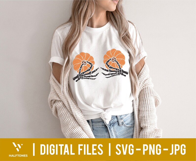May include: A white t-shirt with a graphic of two skeleton hands holding orange pumpkins. The text "DIGITAL FILES | SVG - PNG - JPG" is at the bottom of the image.