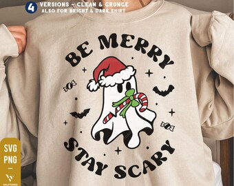May include: Beige sweatshirt with a graphic of a ghost wearing a Santa hat and holding a candy cane. The text "BE MERRY STAY SCARY" is in a circular design around the ghost. Includes bats, candy, and stars.
