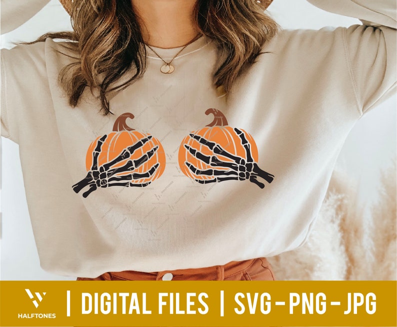 May include: A light beige sweatshirt with a graphic of two orange pumpkins with black skeletal hands holding them.