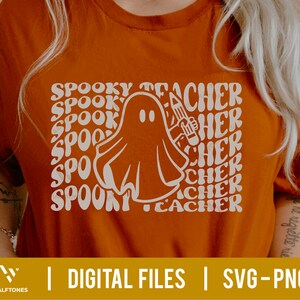 May include: Orange t-shirt with a white ghost holding a pencil and the text "Spooky Teacher" repeated in a retro font.