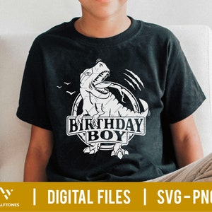 May include: A black t-shirt with a white graphic of a dinosaur roaring with the text "Birthday Boy" in a circle.