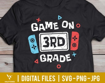 Può includere: Maglietta nera con un design grafico bianco di un controller per videogiochi con il testo "GAME ON 3RD GRADE".