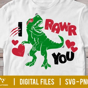 May include: A white t-shirt with a green dinosaur wearing a red bandana and the words "Rawr You" in black and red. The dinosaur has a heart in its mouth and there are hearts around it.