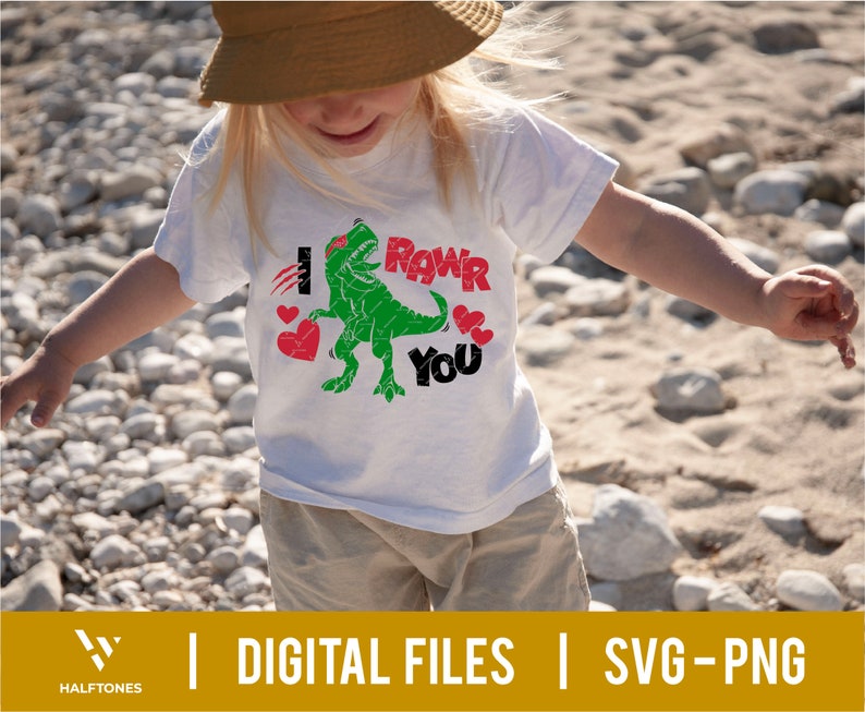 May include: A white t-shirt with a green dinosaur graphic and the text "I Roar You" in red and black letters. The dinosaur is holding a red heart in its mouth.
