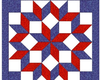 May include: A Carpenter's Block quilt square featuring a starburst design. The design incorporates red, white, and blue geometric shapes. The outer border is a blue floral pattern. The text "Carpenter's Block" is at the top.