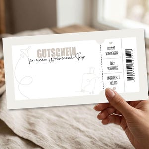 May include: A light beige gift certificate for a weekend trip. The certificate has a minimalist design with a line drawing of a suitcase and airplane. Text includes "GUTSCHEIN f&uuml;r einen Wochenend-Trip" and other phrases.