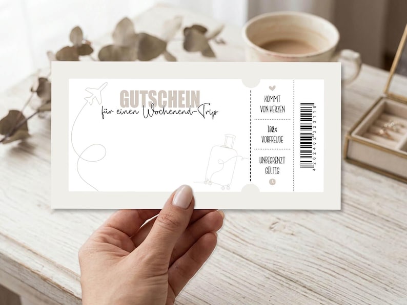 May include: A gift certificate with the text "GUTSCHEIN f&uuml;r einen Wochenend-Trip" in a light gray font. The certificate has a drawing of an airplane and a suitcase. The text "KOMMT VON HERZEN, 100% VORFREUDE, UNBEGRENZT G&Uuml;LTIG" is also visible.