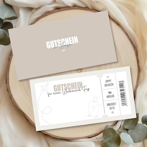May include: Two beige gift certificates with German text. One certificate has the text "GUTSCHEIN von Herzen" and the other says "GUTSCHEIN f&uuml;r einen Wochenend Trip" with a luggage and airplane graphic. The certificates are on a wooden surface.