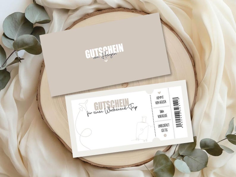 May include: Two beige gift certificates with German text. One certificate has the text "GUTSCHEIN von Herzen" and the other says "GUTSCHEIN f&uuml;r einen Wochenend Trip" with a luggage and airplane graphic. The certificates are on a wooden surface.