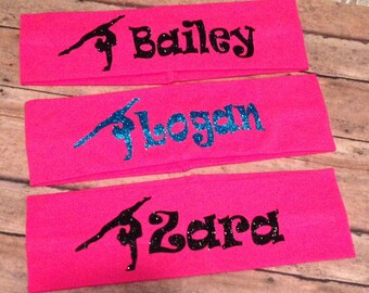 May include: Three pink headbands with a gymnast silhouette and a name in black glitter. The names are Bailey, Logan, and Zara.