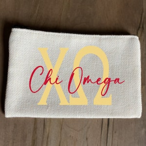 May include: A small, white canvas pouch with a zipper closure. The pouch has the Greek letters "ΧΩ" in yellow and the words "Chi Omega" in red cursive.