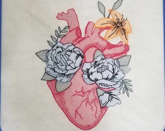 May include: Embroidered design of a red anatomical heart with white and gray flowers and green leaves. The design is in a blue embroidery hoop.