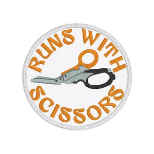 May include: Embroidered patch with the phrase "RUNS WITH SCISSORS" in orange, encircling a pair of scissors. The scissors are gray and black with an orange handle. The patch is circular with a white background and a silver border.