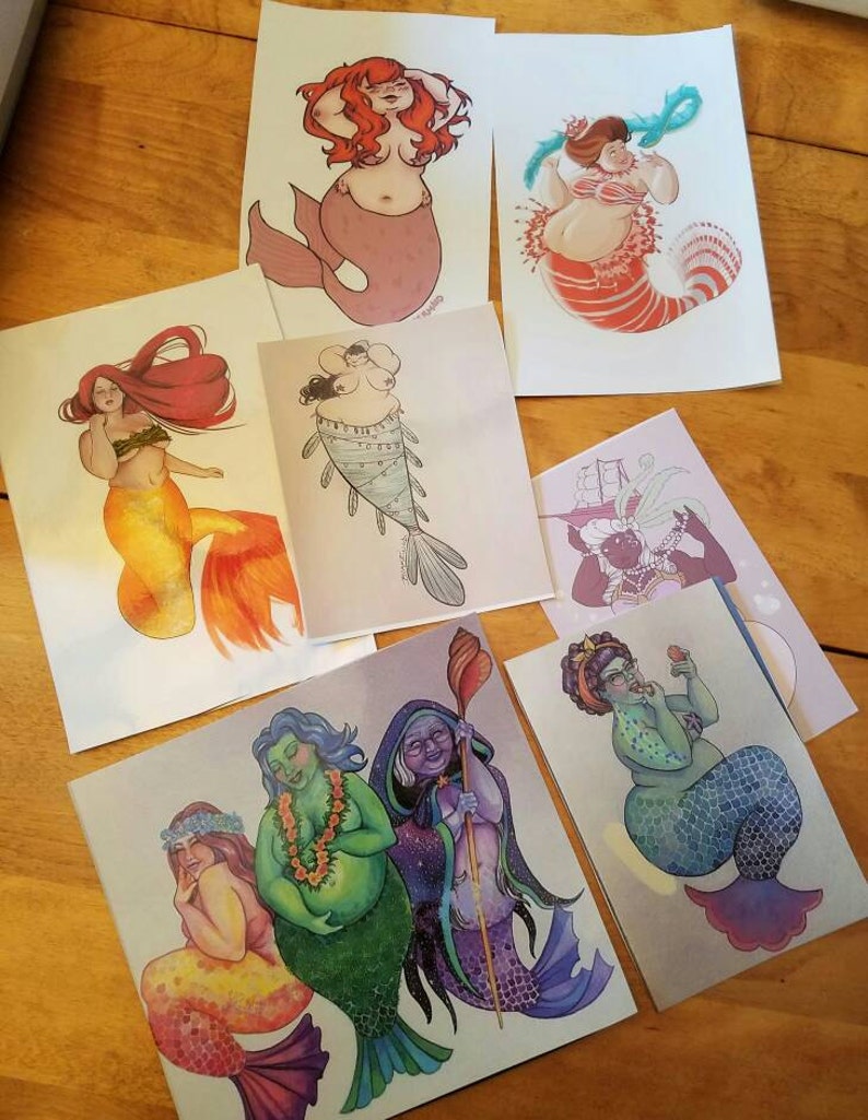 May include: Set of six illustrated cards featuring mermaids with different body types, hair colors, and tail designs. The cards are printed on white cardstock and have a matte finish.