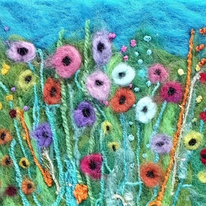 Könnte beinhalten: Ein farbenfrohes Nadelfilzbild, das ein Feld mit Blumen in verschiedenen Schattierungen von Rosa, Lila, Rot, Orange, Gelb und Blau darstellt. Die Blumen sind von grünen und blauen Wollfasern umgeben, die einen strukturierten Hintergrund bilden.