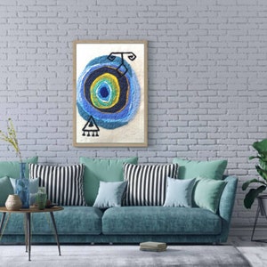 May include: A framed abstract art print with a blue, yellow, and green circle design on a white background. The print is hanging on a white brick wall above a blue couch with striped pillows.