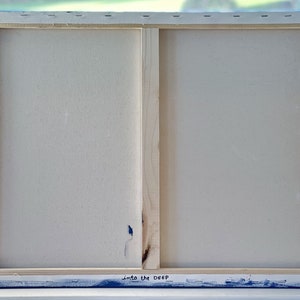 Puede incluir: Parte trasera de una obra de arte en lienzo con marco de madera. El lienzo es blanco y el marco es de madera. Los bordes del lienzo est&aacute;n pintados de azul. El texto "into the DEEP" est&aacute; escrito en tinta negra en el borde inferior.