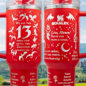 a pair of red travel mugs sitting on top of a table