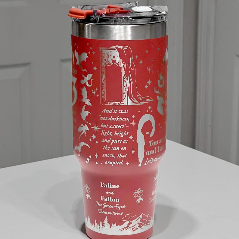 A red tumbler with a lid and a printed quote on it.