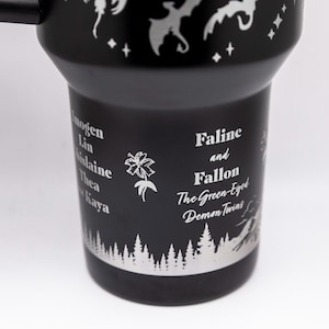 a black travel mug with white designs on it