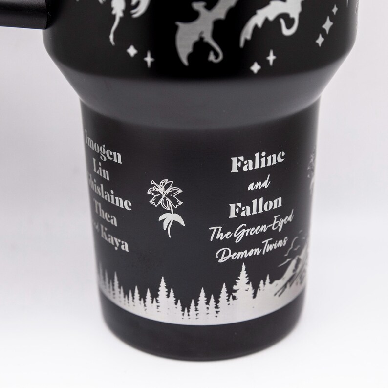 a black travel mug with white designs on it
