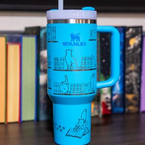 a blue travel mug sitting on top of a table