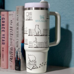 a coffee cup sitting on top of a book shelf