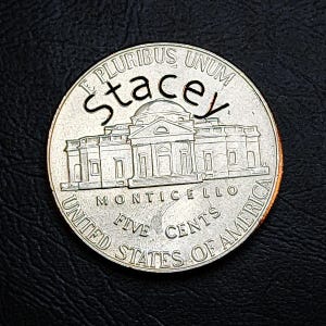 Könnte beinhalten: Eine silberne US-Nickel-Münze mit dem Wort "Stacey" über dem Monticello-Gebäude. Die Münze zeigt die Aufschrift "E PLURIBUS UNUM", "MONTICELLO", "FIVE CENTS" und "UNITED STATES OF AMERICA".