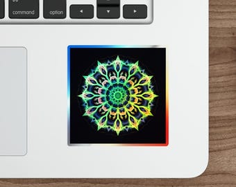 May include: A square sticker featuring a vibrant, colorful mandala design. The mandala has a black background with a rainbow gradient border. The sticker is placed on a white laptop.