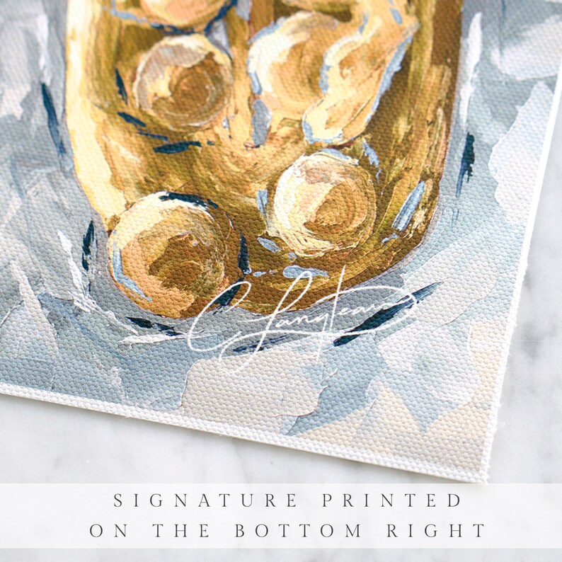 May include: Close-up of an abstract painting with a textured, golden-yellow central form. The artwork features a light blue and white background with brushstrokes. The artist's signature is printed on the bottom right.