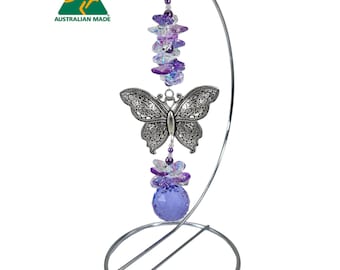 May include: A decorative wind chime featuring a silver butterfly, purple crystals, and a large purple crystal ball. The wind chime hangs from a silver metal stand. The image includes the text "AUSTRALIAN MADE".