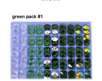 May include: A tray of octagon-shaped crystals in various shades of green and clear. The text "1 hole octagon crystals 100 pieces" and "green pack #1" are visible. The crystals are arranged in a grid pattern.