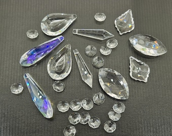 Puede incluir: Surtido de colgantes de prisma de cristal transparente en varias formas y tamaños, incluyendo formas de lágrima, hoja y estrella. Los cristales son iridiscentes y brillan a la luz.