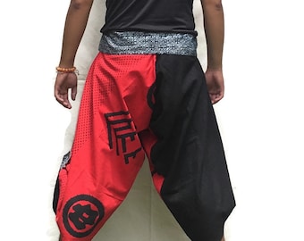 May include: A person wearing black and red pants with a black belt and a black sleeveless shirt. The pants have a red and black pattern with Japanese characters.