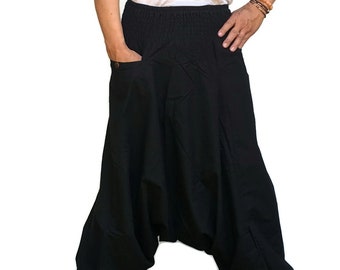 May include: Black cotton pants with a wide, loose fit and a drawstring waist. The pants have a single pocket on the left side.
