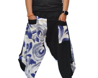 May include: A person wearing black sleeveless shirt and black and white patterned pants with blue swirls. The pants have large pockets on the sides.