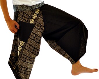May include: Black harem pants with a decorative gold elephant pattern on the pockets and side panels. The pants have a wide waistband and a loose, comfortable fit. The model is wearing a white tank top.