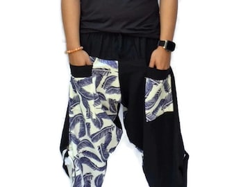 May include: Black and white patterned pants with a black top. The pants have a unique design with a white background and blue feather print on one side and black fabric on the other side.