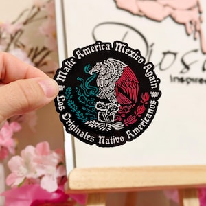 May include: A black and white sticker with a red, white, and green eagle design. The sticker says "Make America Mexico Again" and "Los Originales Nativo Americanos".