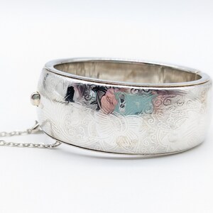 Brazalete ancho con bisagras bañado en plata y diseño floral grabado - 7"
