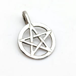 May include: A silver-colored pendant featuring a pentagram within a circle. The pendant has a loop at the top for a chain. The design is simple and the metal has a slightly textured appearance.