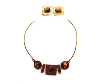 May include: A gold necklace with a geometric design and tiger's eye stones. The necklace is paired with matching earrings.