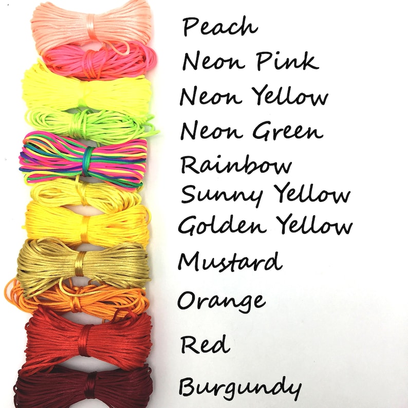 May include: A collection of colorful satin cord spools in peach, neon pink, neon yellow, neon green, rainbow, sunny yellow, golden yellow, mustard, orange, red, and burgundy. Text on the right lists the colors.