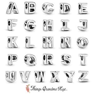 May include: A set of 26 silver charm beads, each featuring a different letter of the alphabet. The beads are designed with an open, hollow letter shape.