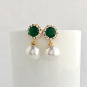 Puede incluir: Pendientes de oro con una piedra preciosa verde rodeada de piedras m&aacute;s peque&ntilde;as transparentes y una perla blanca.
