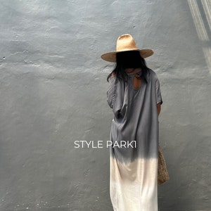 May include: A gray and white ombre maxi dress with a keyhole back detail. The dress is worn by a person wearing a wide-brimmed straw hat. The text "STYLE PARKI" is visible in the image.