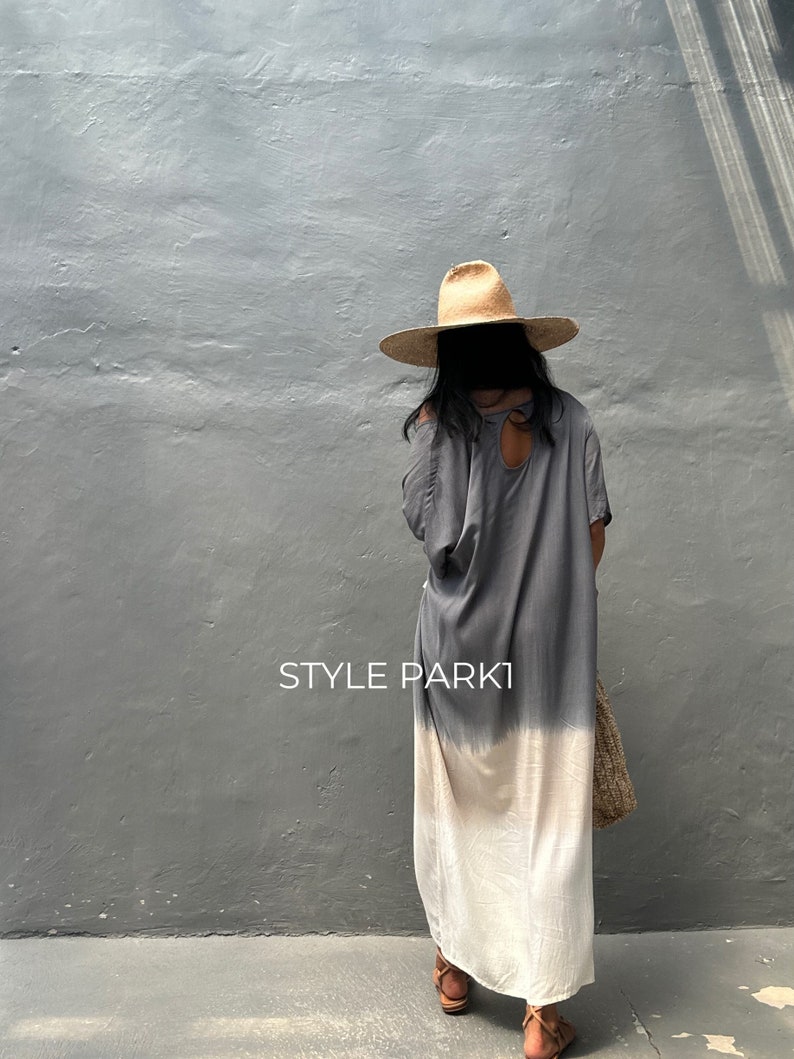 May include: A gray and white ombre maxi dress with a keyhole back detail. The dress is worn by a person wearing a wide-brimmed straw hat. The text "STYLE PARKI" is visible in the image.