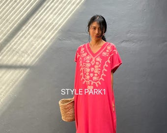 May include: A vibrant pink dress with short sleeves and a V-neck, featuring intricate embroidered patterns in a lighter shade. The dress has side slits and is paired with a woven basket. The text "STYLE PARK1" is visible.